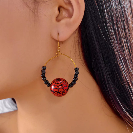 18K gold-plated Halloween bead earrings featuring a red spider-web bead framed by black beads on a gold hoop