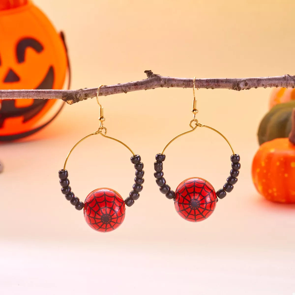 18K gold-plated Halloween bead earrings with red spider-web beads and black seed beads on gold hoops.