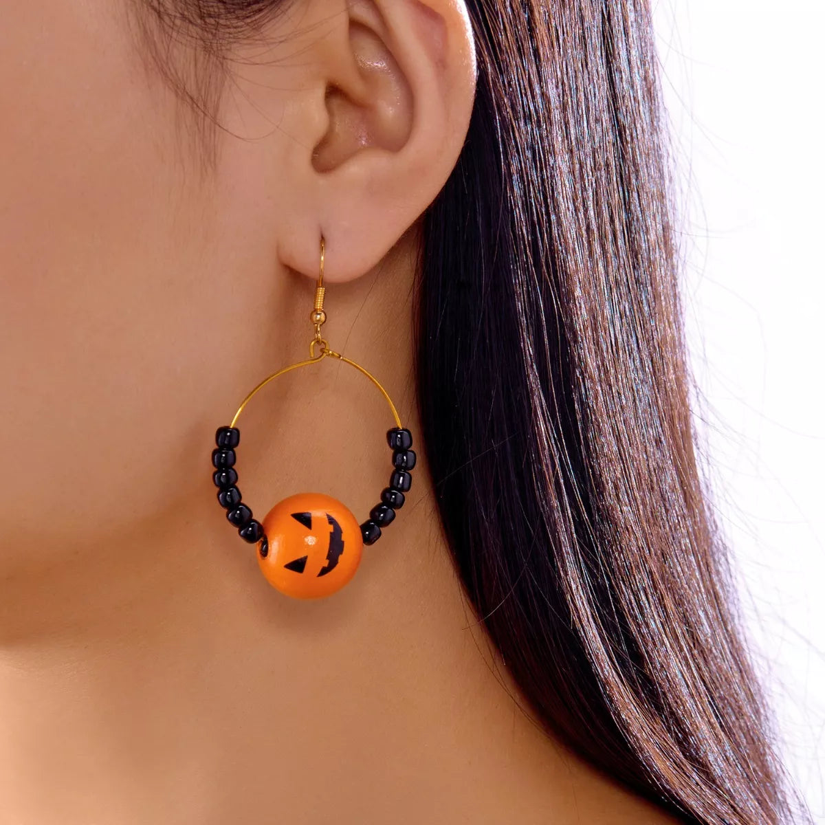 18K gold-plated Halloween bead earrings with orange pumpkin bead and black seed beads on hoop.